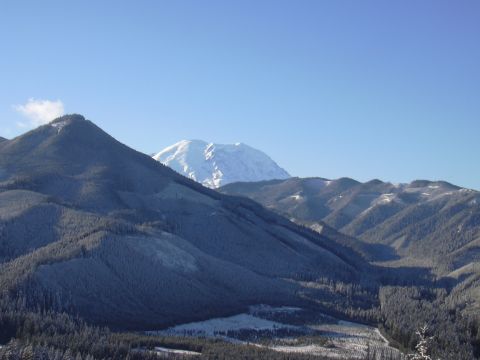 1991 Ford Bronco - A vast mountain landscape under a bright blue sky, with snow covering the peaks and trees.