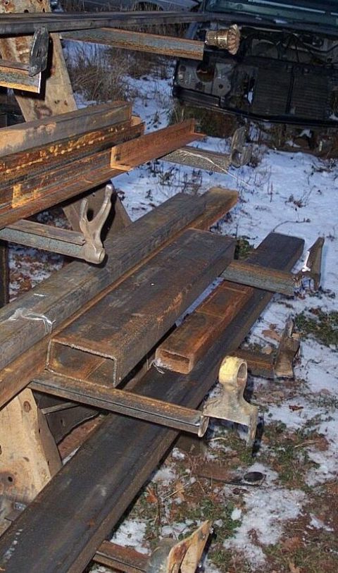 1990 Ford Bronco - Metal framing and vehicle chassis parts are visible in a snowy outdoor setting.