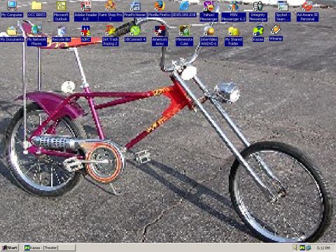 1993 Ford Taurus - A custom chopper bicycle is parked outdoors on an asphalt surface.