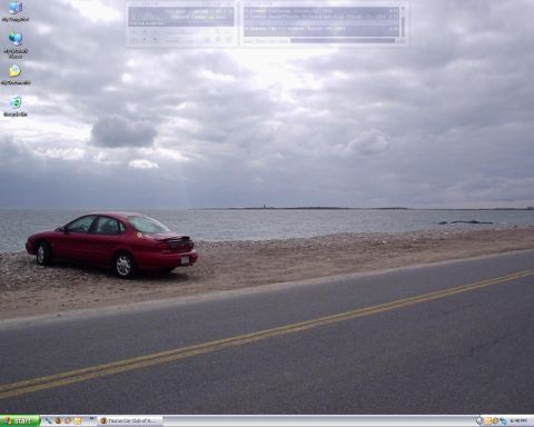 1998 Ford Taurus - A red 1998 Ford Taurus is parked on a gravel shoulder overlooking a calm body of water under a cloudy sky.