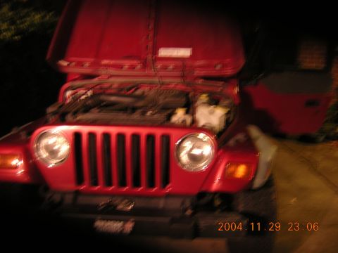 1984 Chevrolet Blazer - A red Jeep Wrangler is parked with its hood open, revealing the engine compartment.