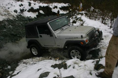 2003 Jeep TJ - A Jeep Wrangler Rubicon navigates a challenging off-road course in snowy conditions.