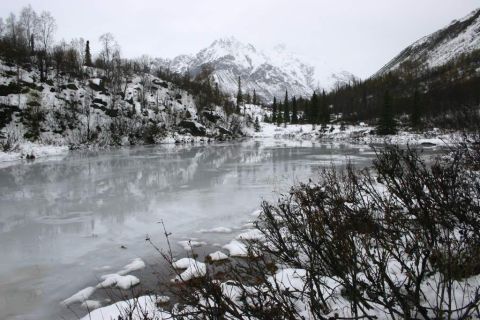2003 Jeep TJ - Winter landscape with a partially frozen lake and snow-capped mountains in the background.