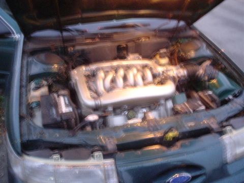 1993 Ford Taurus - Engine bay of a 1993 Ford Taurus SHO, V6 engine visible.