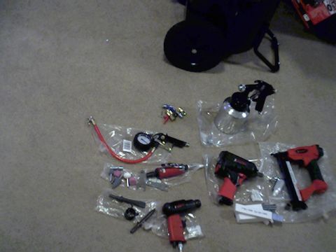 1987 Ford Bronco - Various air-powered tools and accessories are laid out on a carpeted surface, including a spray gun, impact wrench, nail gun, and tire infl…