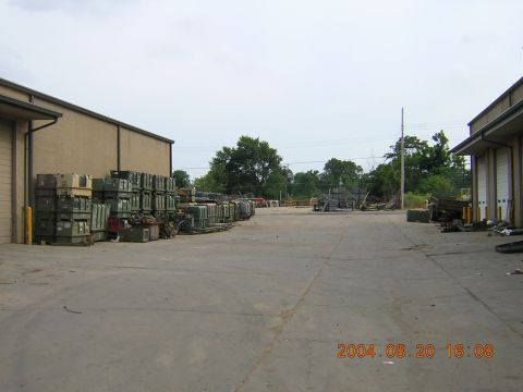 1984 Chevrolet Blazer - A view of an outdoor storage area with stacks of crates and some vehicles in the background.