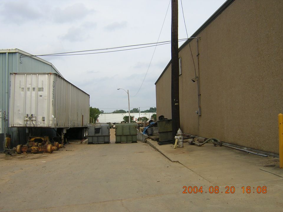 Industrial yard with a parked trailer, dumpsters, and a fire hydrant