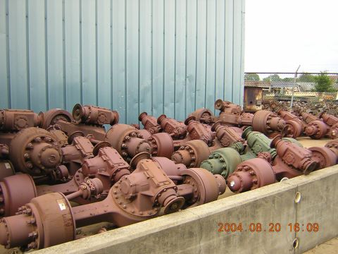 1984 Chevrolet Blazer - A large collection of truck axles, many showing signs of rust, are piled up outdoors.