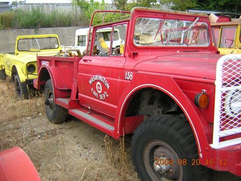 1984 Chevrolet Blazer - A red fire department truck is parked next to a yellow vehicle, with a white truck in the background.