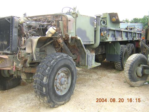 1984 Chevrolet Blazer - Weathered military dump truck with engine compartment open, parked outdoors.