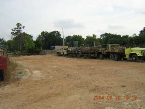 1984 Chevrolet Blazer - A collection of military trucks, including a lime green one, are parked in an outdoor lot.