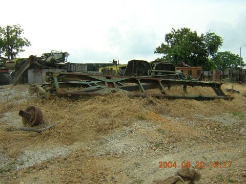 1984 Chevrolet Blazer - Junkyard scene with a heavily rusted vehicle frame in the foreground.