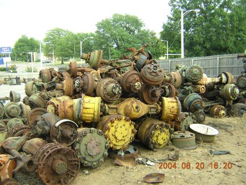 1984 Chevrolet Blazer - A large pile of used truck axles and differential parts are stored outside.