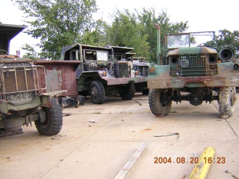 1984 Chevrolet Blazer - Several aging military trucks, showing signs of wear and tear, are parked in an outdoor lot.