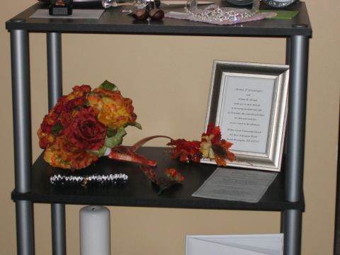 1985 Ford LTD Crown Victoria - A framed document and a bouquet of flowers are displayed on a shelf, alongside other decorative items.