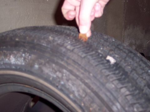 2001 Ford Crown Victoria - A penny is inserted into the tread of a tire to check tread depth.