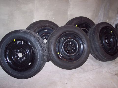2001 Ford Crown Victoria - Set of four spare tires, some with handwritten markings, stored indoors.