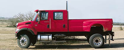 1990 Ford Bronco - A red crew cab truck is shown from the side in an outdoor setting.