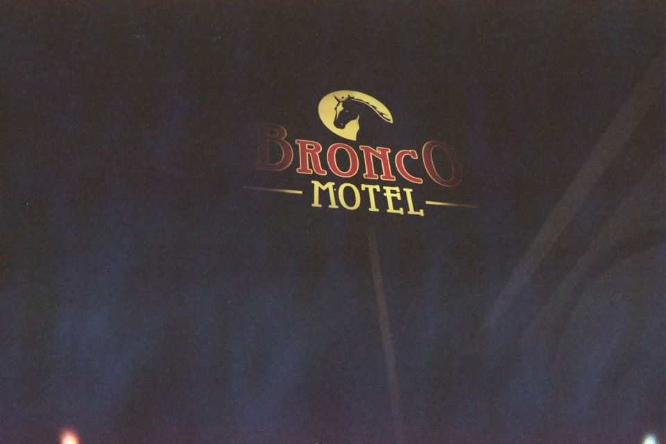 Bronco Motel illuminated sign with horse-head logo and red lettering at night
