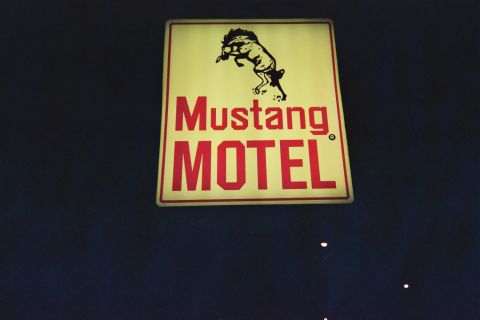 1968 Ford Mustang - A lit sign for the Mustang Motel hangs against a dark background.