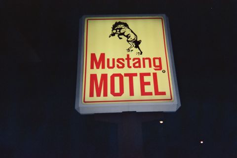 1968 Ford Mustang - A lit sign for the Mustang Motel features a silhouette of a horse and bold red lettering.
