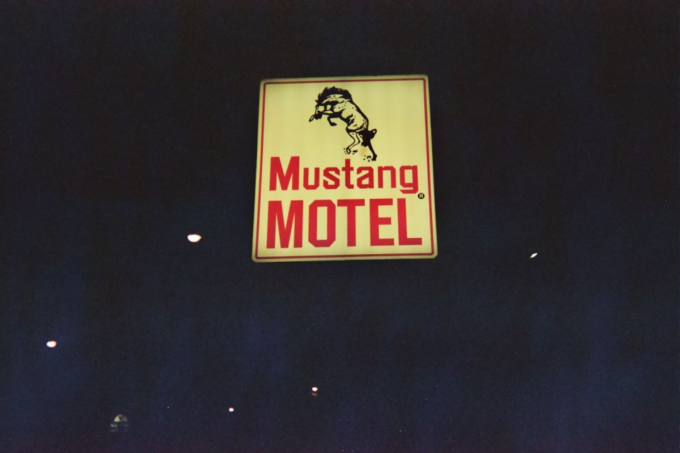 Mustang Motel sign with a leaping horse graphic and red text