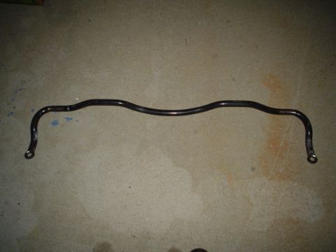 1993 Ford Taurus - A single sway bar lies on a concrete surface, likely a replacement part for a vehicle.