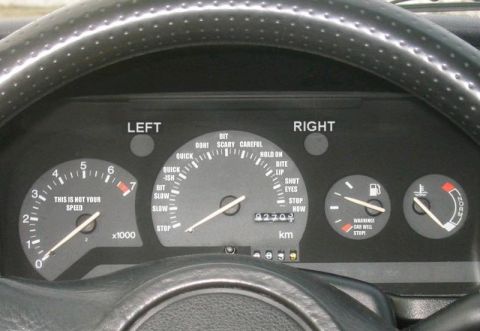 2003 Jeep TJ - The interior dashboard features a tachometer, speedometer, fuel gauge, and temperature gauge, along with various warning lights.