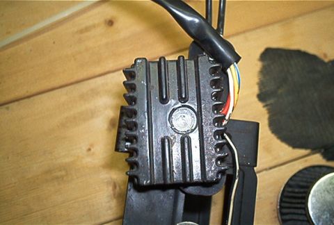 1985 Ford LTD Crown Victoria - A close-up view of a vehicle's voltage regulator, a crucial component for managing electrical power.