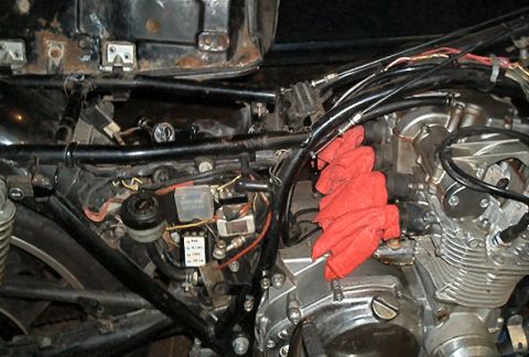 1985 Ford LTD Crown Victoria - Motorcycle engine and frame details, with red rags obscuring some components.