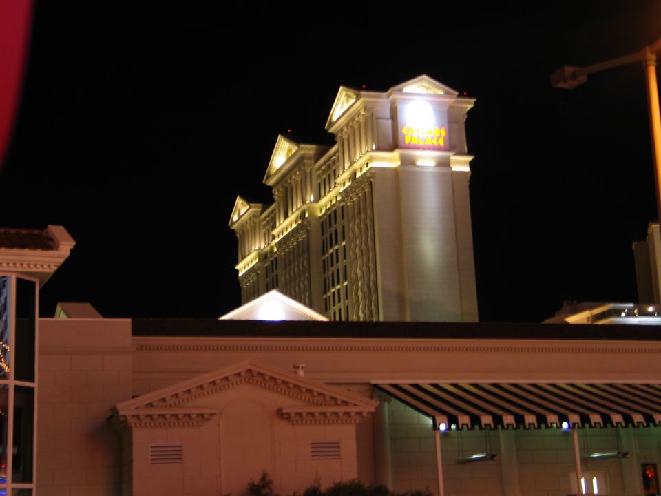 Caesars Palace hotel sign illuminated at night with a dark sky
