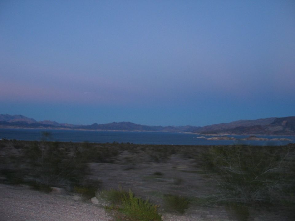 Desert landscape with lake and mountains at dusk, Supermotors.net logo