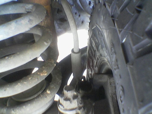 Close-up of suspension and tire with visible Supermotors.net watermark