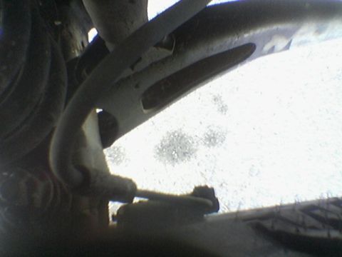 1990 Ford Bronco - Underside view of vehicle suspension components, showing a brake line and control arm.