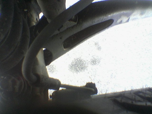 Close-up of vehicle suspension parts, possibly a control arm and brake line