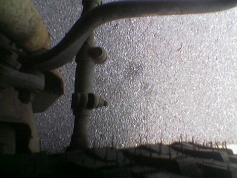 1990 Ford Bronco - Close-up view of vehicle suspension components and tire tread on asphalt.