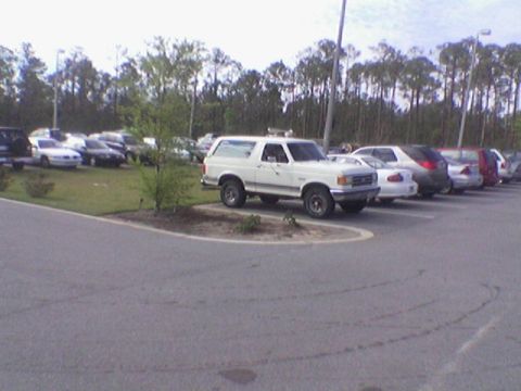 1990 Ford Bronco - This white 1990 Ford Bronco is parked in a lot with other vehicles.