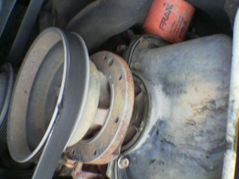 1990 Ford Bronco - Close-up view of an engine's pulley system and an orange oil filter.