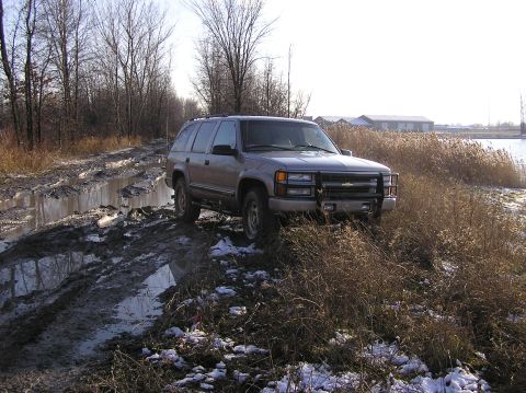 2000 Chevrolet Tahoe - This SUV navigates a challenging muddy path with snow on the ground.