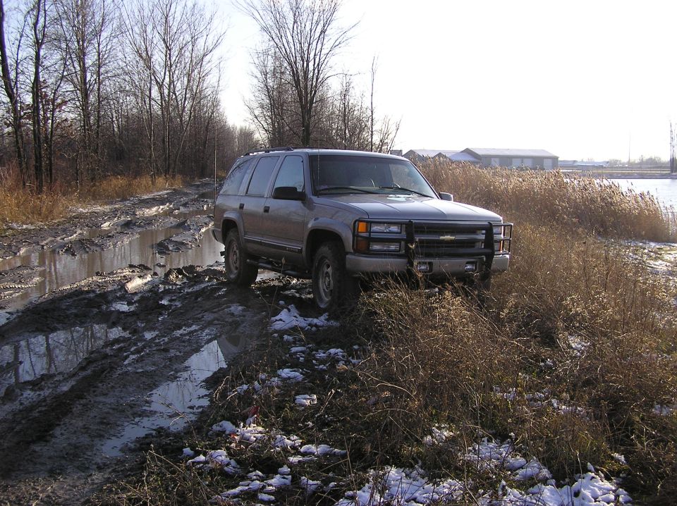 Gray SUV with brush guard on muddy road