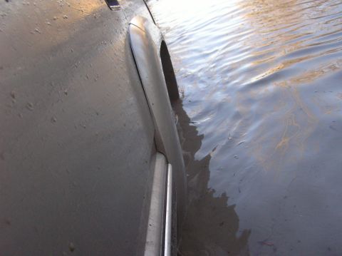 2000 Chevrolet Tahoe - The vehicle is driving through a body of water, with the lower body and wheel partially submerged.