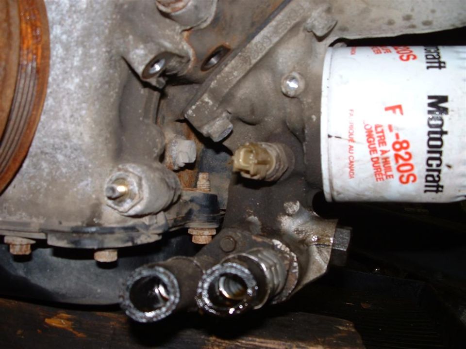 Engine accessory area with white Motorcraft FL-820S oil filter and disconnected fuel lines