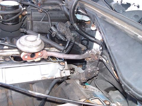 1996 Ford Crown Victoria - Visible exhaust leak and damaged pipework in the engine compartment.