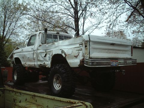 1979 Ford F-150 - This heavily damaged 1979 Ford F-150 pickup truck is seen from the rear while on a trailer.