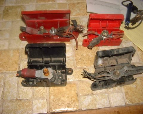 1985 Ford F-150 - Four automotive battery cable connectors are laid out on a tiled surface.