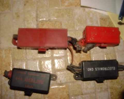 1985 Ford F-150 - Several automotive electrical components, including fuse boxes, are laid out on a tiled surface.