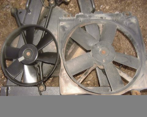 1985 Ford F-150 - Two radiator fans are shown, one smaller than the other, against a dirt and debris background.
