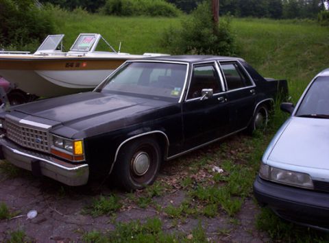 1991 Ford LTD Crown Victoria - A black sedan with a chrome grille and trim is parked outdoors.