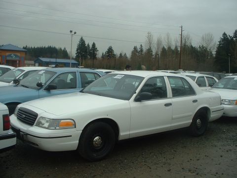 1999 Ford Crown Victoria - White Ford Crown Victoria sedan parked outdoors in a lot with multiple other vehicles visible.