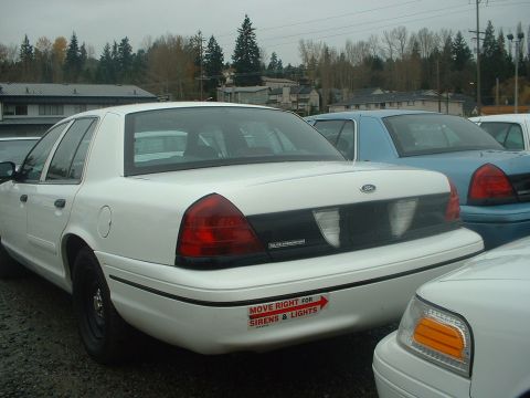 1999 Ford Crown Victoria - This police car has a bumper sticker instructing other drivers to move right for emergency vehicles.